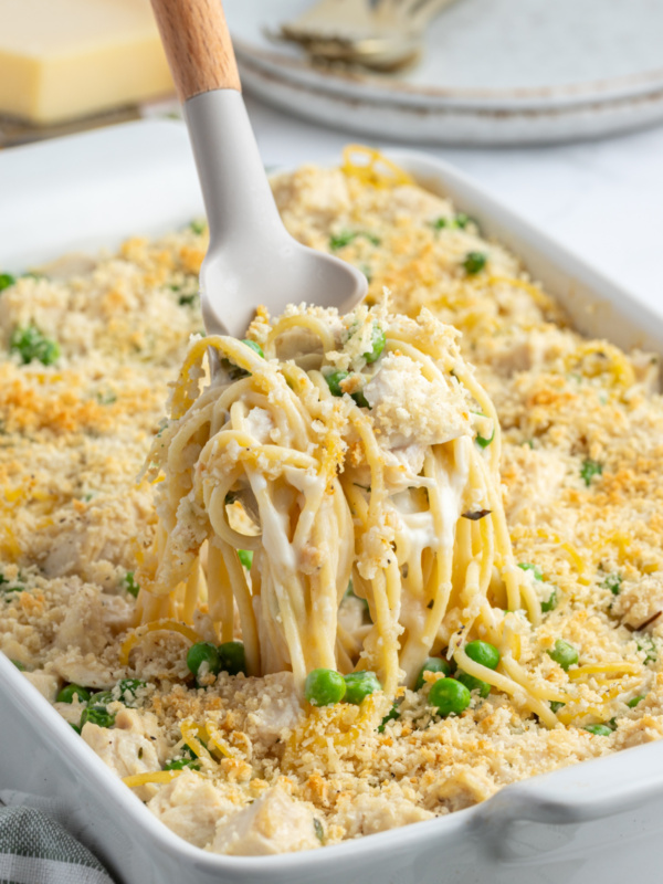 spooning out scoop of turkey tetrazzini from pan