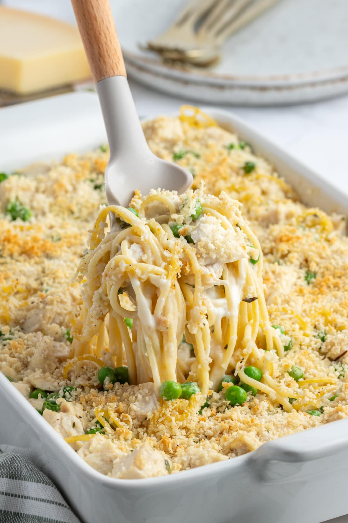 spooning out scoop of turkey tetrazzini from pan