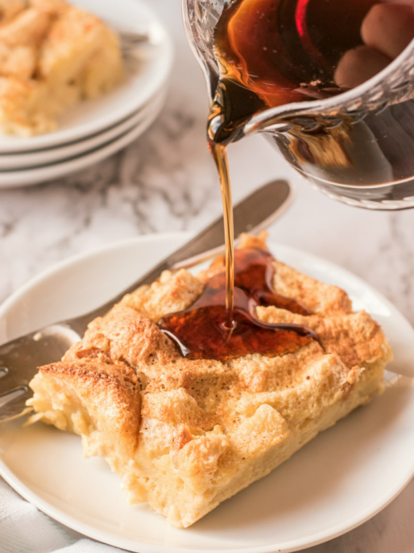 syrup poured over slice of maple custard bread pudding