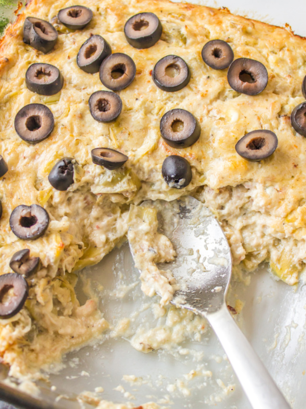 warm crab dip in a baking dish with a spoon