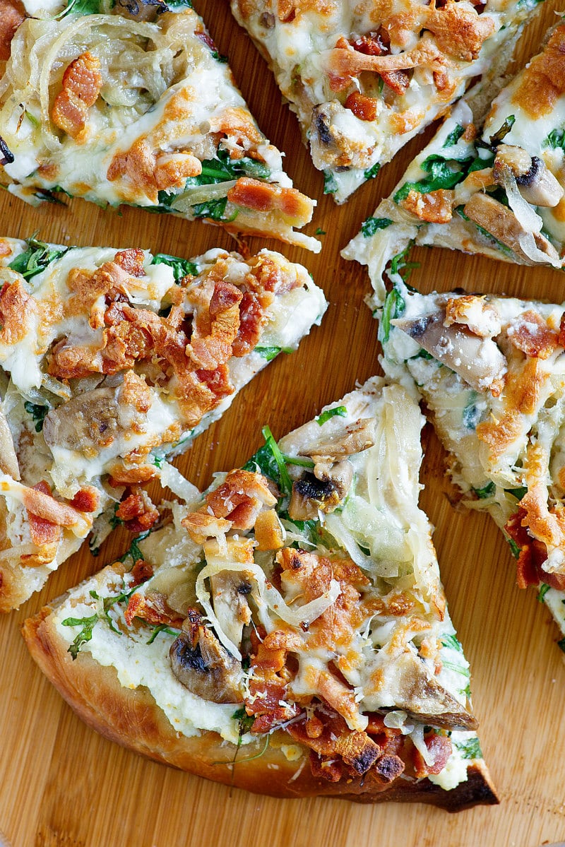 overhead shot of white pizza cut into slices on a cutting board