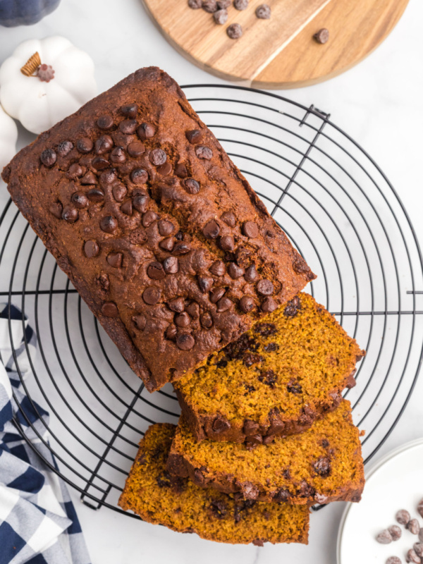 loaf of whole wheat chocolate chip pumpkin bread on a rack sliced open